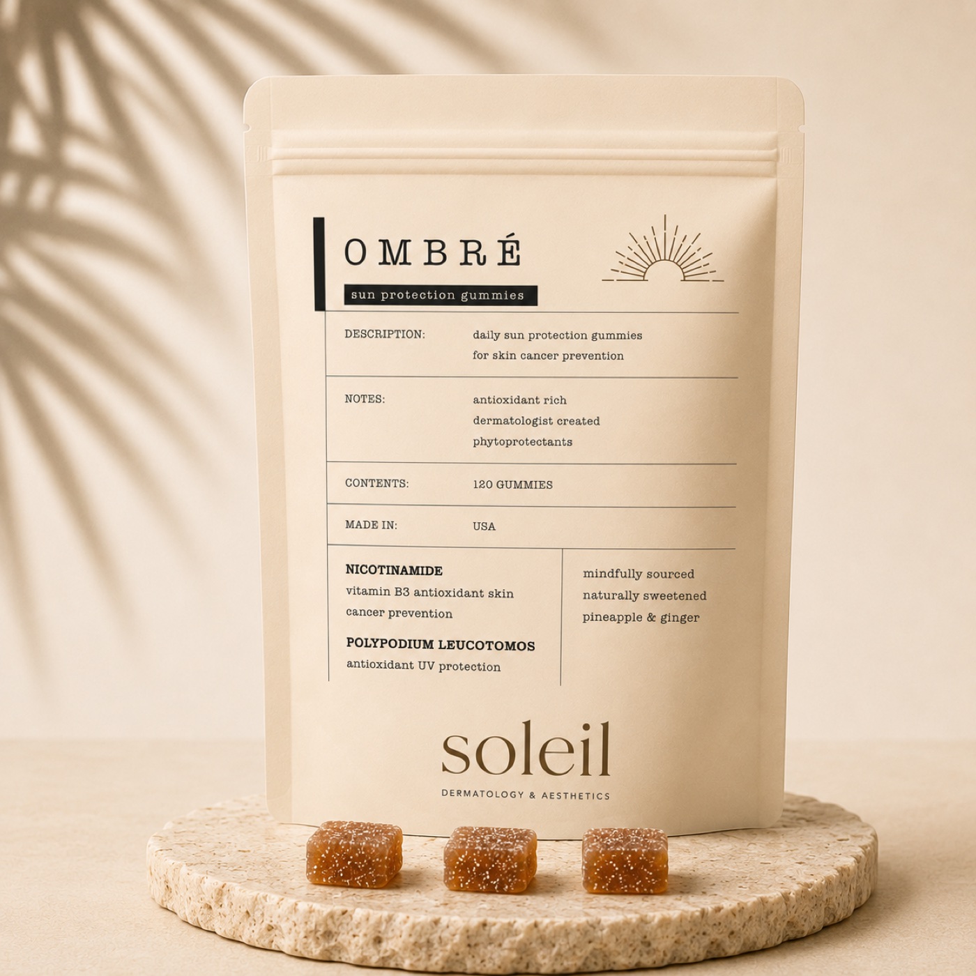 Pouch of Ombré Sun Protection Gummies on a stone tray with three gummies