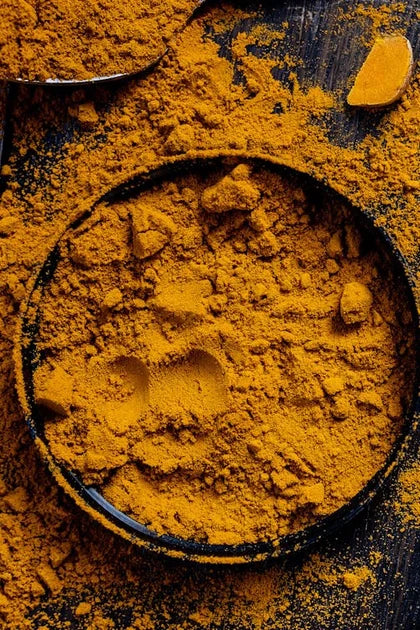 Ground turmeric in a dark bowl
